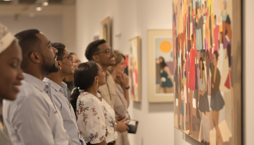Visiteurs admirant des œuvres d'art colorées dans une galerie moderne