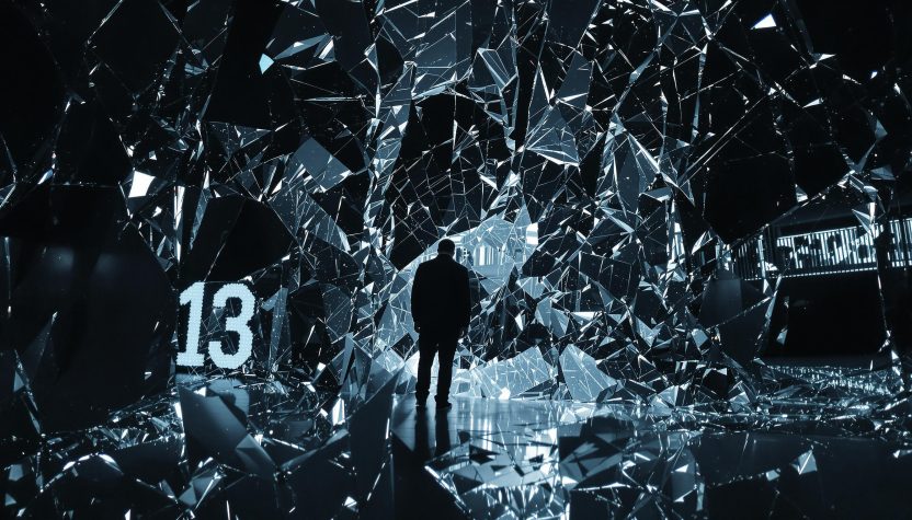 Homme en costume dans un tunnel de miroirs futuriste éclaté