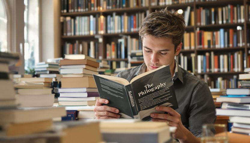 Étudiant lisant un livre de philosophie dans une bibliothèque universitaire