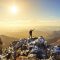 Un homme au sommet d'une montagne au lever du soleil.